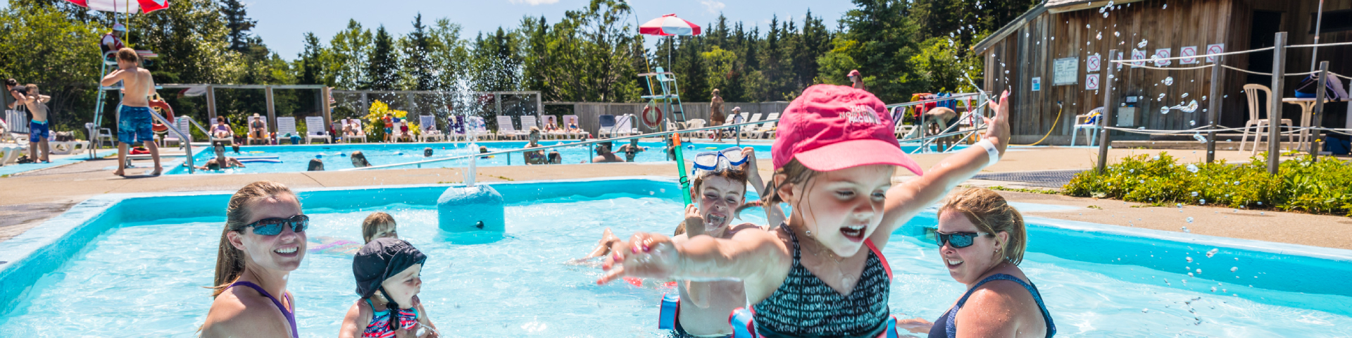 Women and kids are enjoying the moment in a paddling pool. 