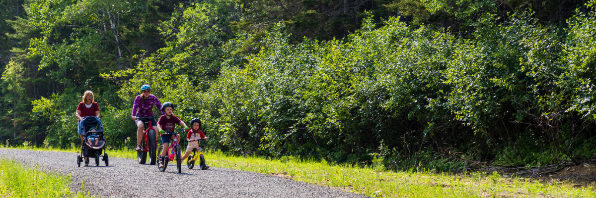 A family is enjoying the Le Castor trail by bike, on foot and with a pushchair.