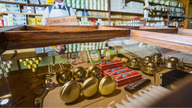 Various objects in a display case in a general store from the early 20th century.