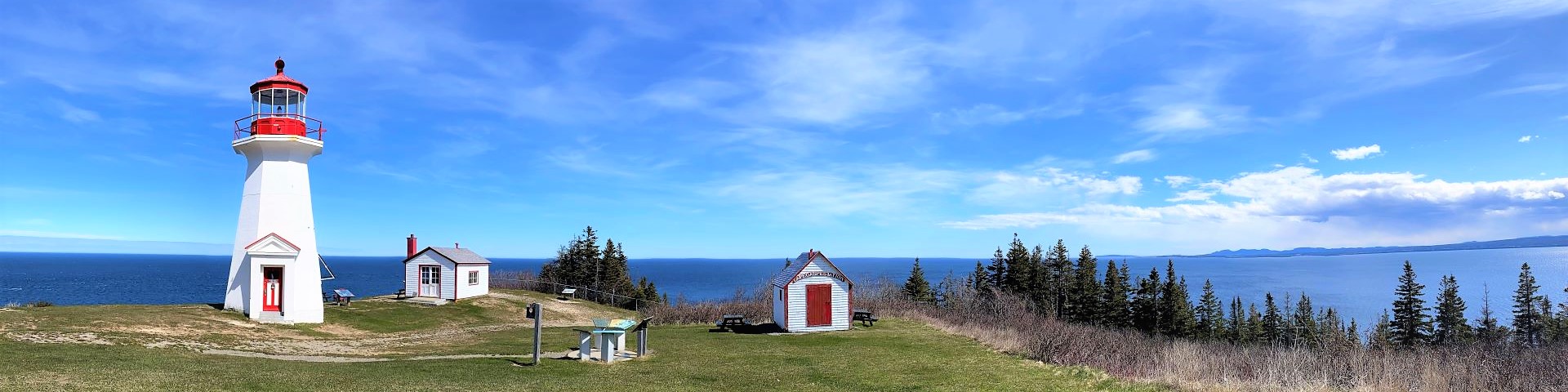 Vue panoramique d'un phare et de bâtiments.