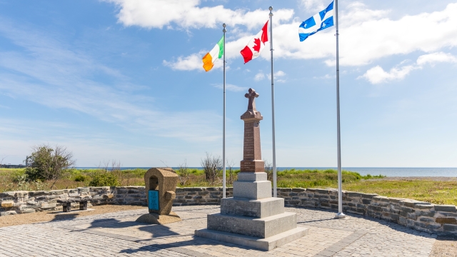 Two stone monuments with three flags. 