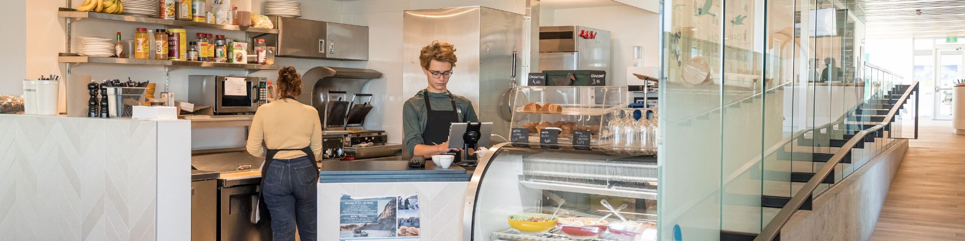 Un homme en fauteuil roulant ergarde la mer sur un tapis universel installé sur une plage. 