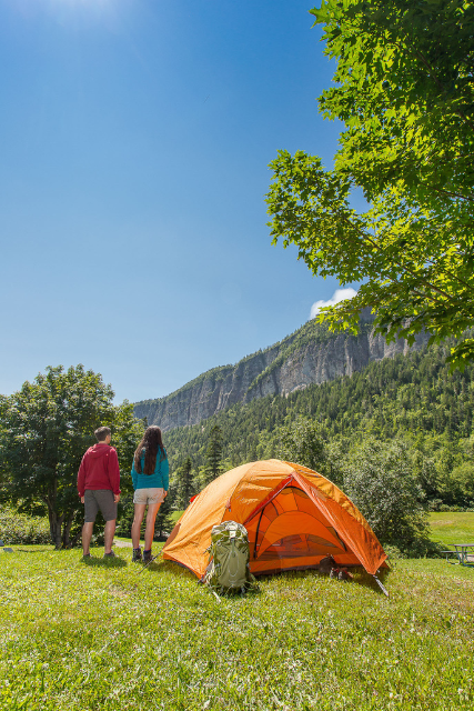 Two campers next to their tent look at the Cap-Bon-Ami cliffs.