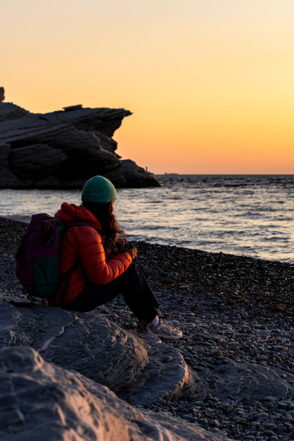 A visitor comtmeplates the sea at sunrise.