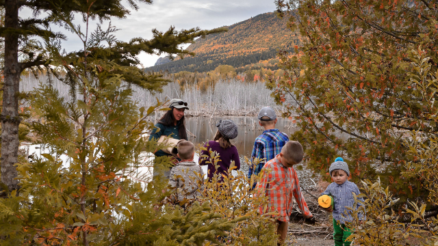 Une employée de Parcs Canada parlent à des enfants près d'un étang.