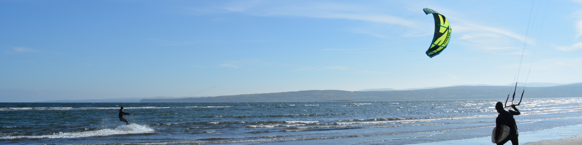 Two people do kitesurfing in the waters of Penouille.