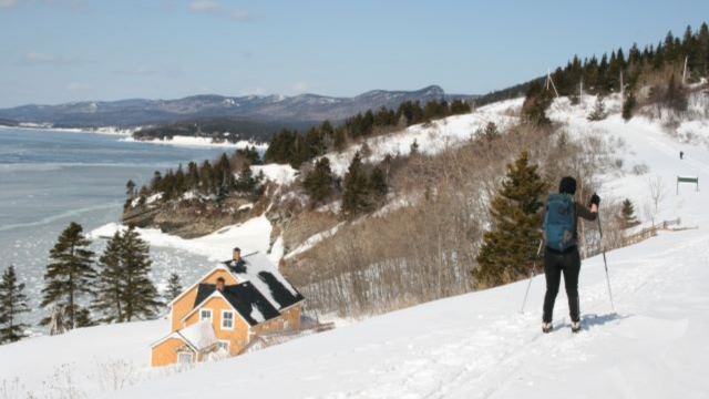 A cross-country skier on a marked trail passes near the Blanchette house in Forillon Park. 