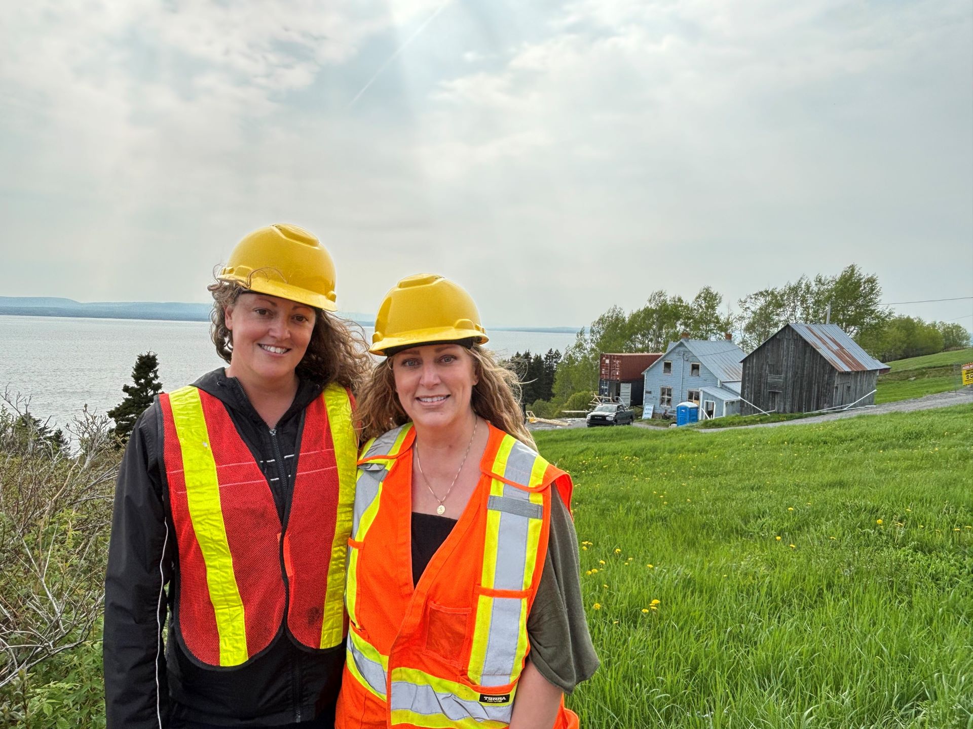 Jennifer and Amanda Roberts posing in front of their ancestor's house at Grande-Grave.