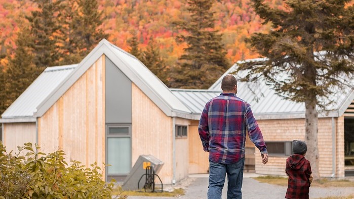 Un père et son fils se dirigent vers l'un des bâtiments de service du camping Petit-Gaspé