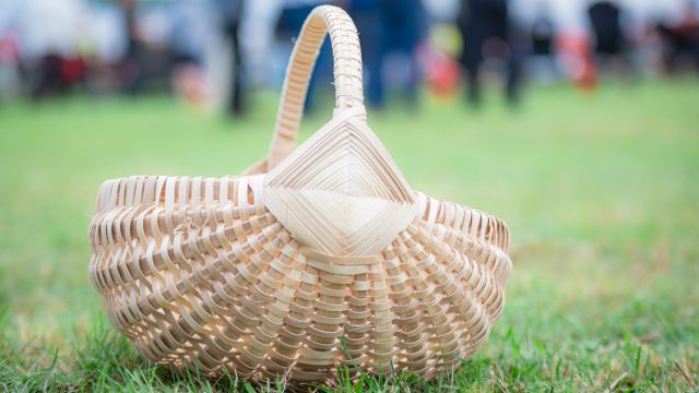 Un panier tressé sur le gazon. 