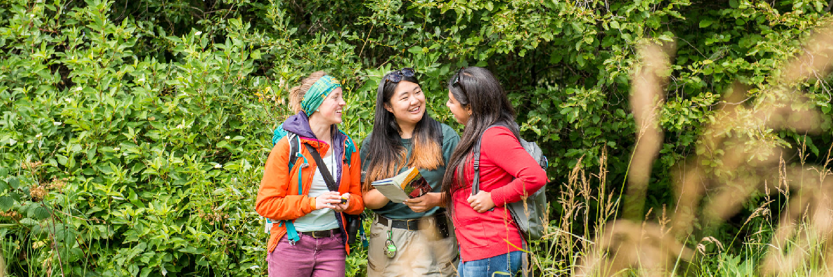 An employee interacts with two visitors.