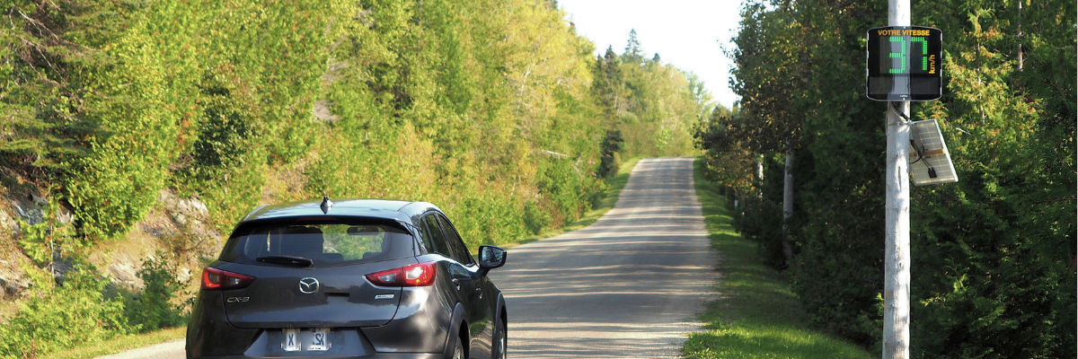 A car passes near an educational radar, an electronic installation displaying the speed of motorists.