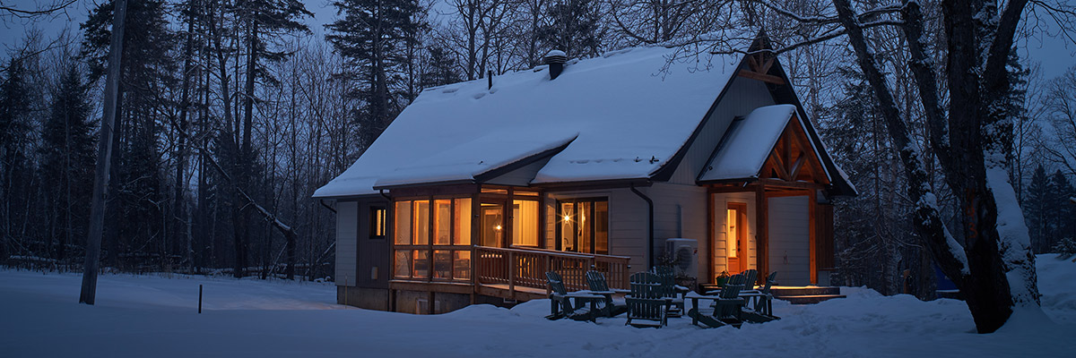 Cabin lit up, seen from the outside, in winter.