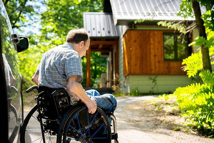 A visitor geting out of his van in front of the cabin.