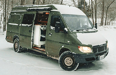 Un véhicule aménagé autonome est stationné dans la neige.