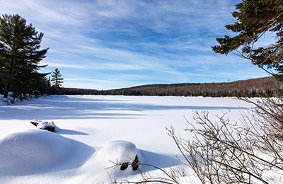 A snow-covered lake with a blue sky.