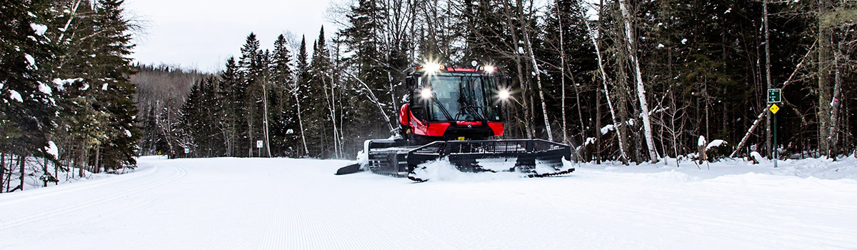 A snow-grooming machine maintains a cross-country ski trail.