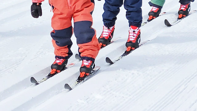 Three children enjoy cross-country skiing.