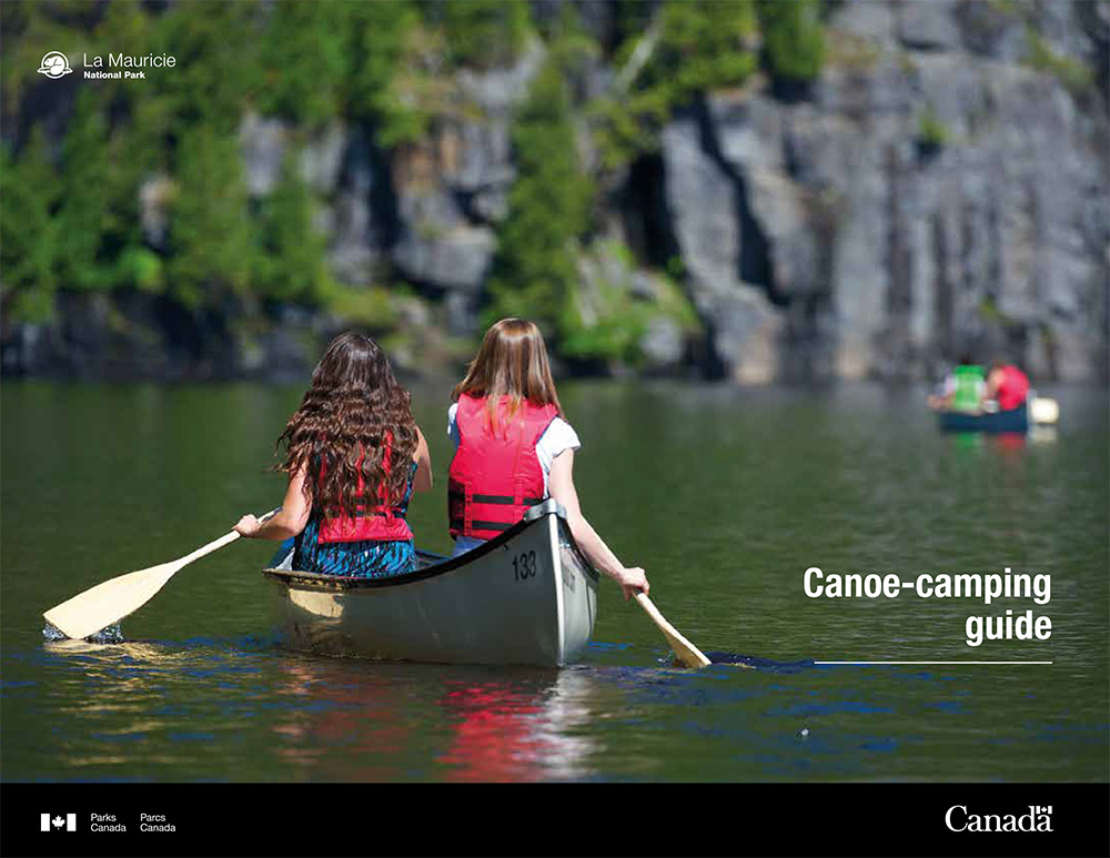2023 canoe-camping guide cover - two young canoers paddling on a calm lake