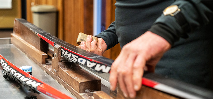 A competitor waxes his skis.