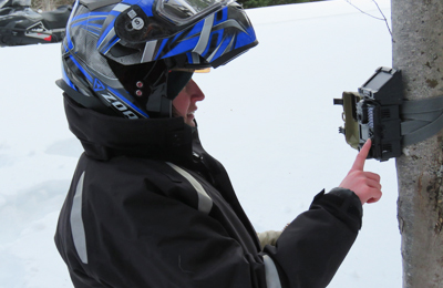 An employee installs a wildlife camera at La Mauricie National Park.