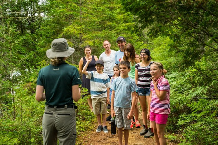 A Parks Canada guide with a group in a trail.