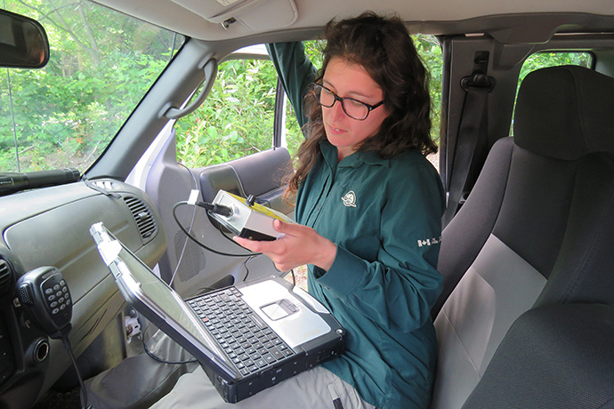 Une employée de Parcs Canada installe un détecteur d'ultrasons à l'intérieur d'un véhicule.