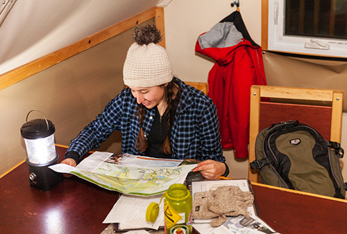 Young woman studying a La Mauricie national Park's map in an oTENTik tent