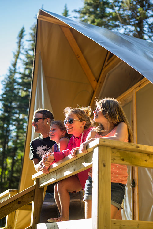A young family on the balcony of an oTENTik tent