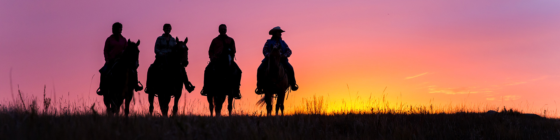 Silhouettes de visiteurs à cheval au coucher du soleil, sur le terrain de parcours libre panoramique du bloc Ouest, au parc national des Prairies.