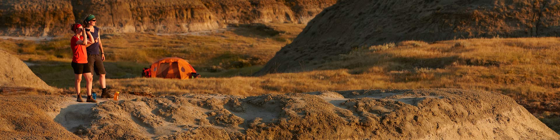 In the badlands area, two young women in camping, discuses in the valley of the 1000 Devils. 