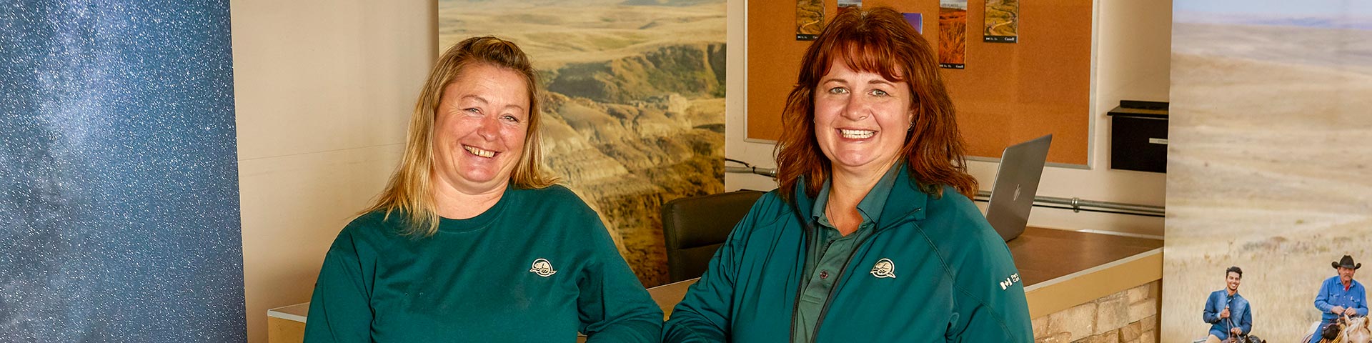 Two visitor services staff at the Frenchman Valley Campground Kiosk, in the West Block of Grasslands National Park.
