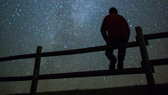 Un visiteur profite des vues spectaculaires de la Voie lactée depuis le camping de la Vallée-de-la-Frenchman, dans la réserve de ciel étoilé, au parc national des Prairies