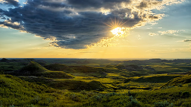 Le soleil se couche sur les collines sauvages des badlands, dans le bloc Est. 