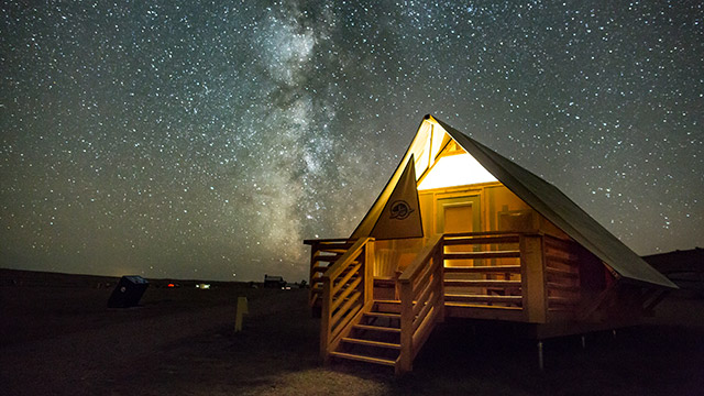  Un abri oTENTik de Parcs Canada entouré de la Voie lactée dans la réserve de ciel étoilé, au parc national des Prairies.