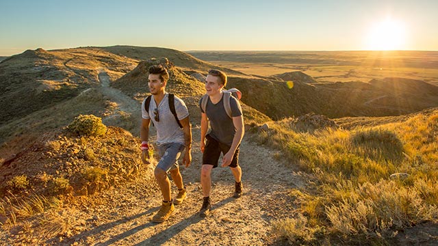 	De jeunes adultes en randonnée sur le sentier de Butte-70-Mile du bloc Ouest, dans le parc national des Prairies.