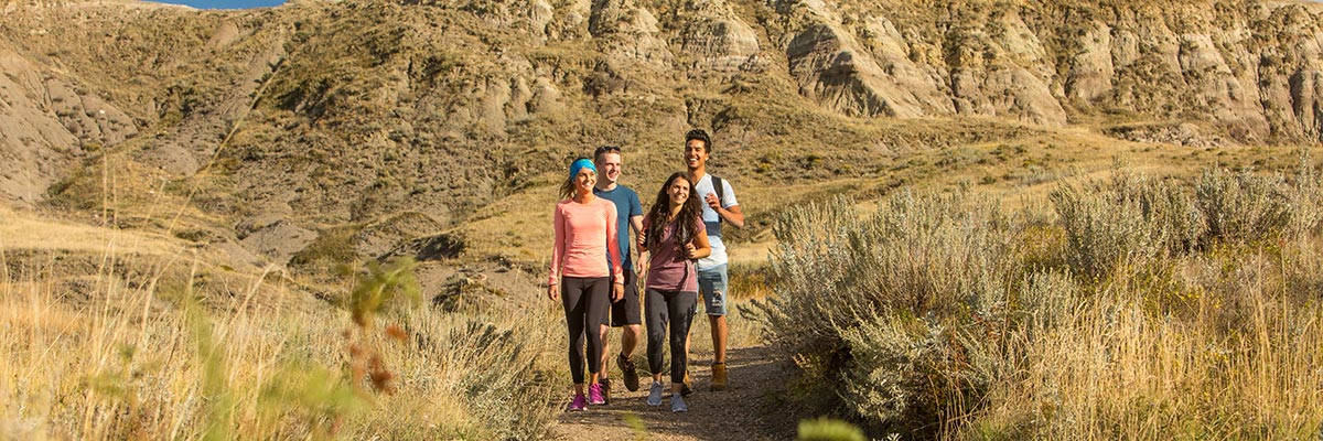 Un groupe de jeunes adultes en randonnée sur le sentier de Butte-70-Mile du bloc Ouest, dans le parc national des Prairies. 