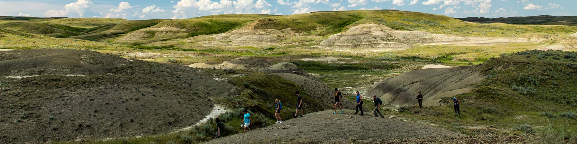 A Parks Canada heritage presenter leads a group of visitors on a hike. 