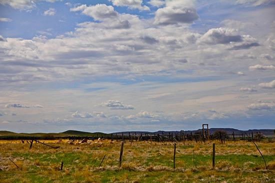 The historic 76 ranch corrals stand out against a blue, cloudy sky.