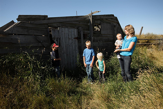 Une famille part en exploration autour des bâtiments du site du homestead Larson.