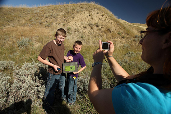 Two boys have their photo taken after finding a geocache.