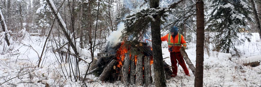 Un membre du personnel surveille le brûlage d’une pile de rémanents dans la nouvelle zone de réduction des combustibles. 