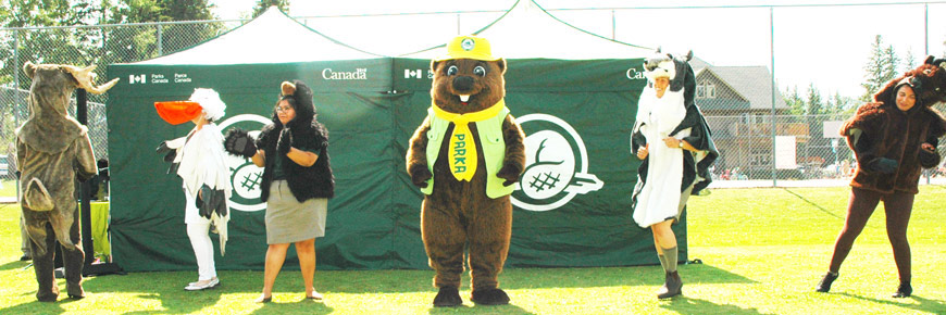 Parka dansant avec des interprètes du parc portant des costumes d’animaux