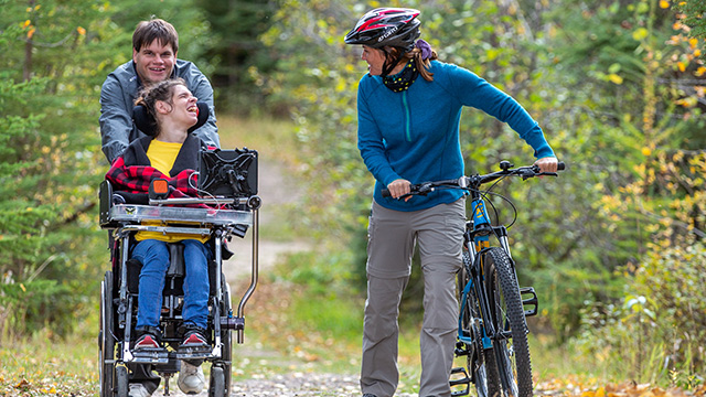 Visitors use the bike and wheelchair accessible trails on the Red Deer Trail at Beaver Glen Campground in Prince Albert National Park.