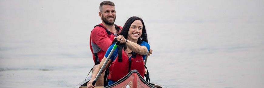 A couple paddles their canoe.