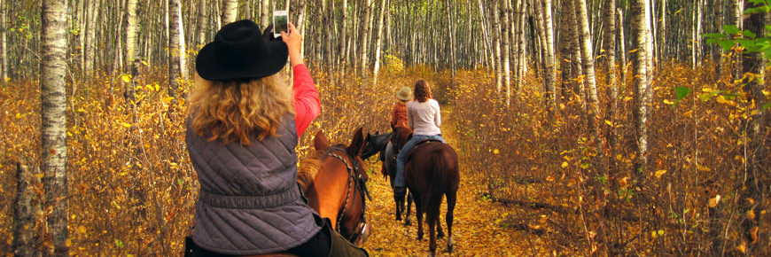 Une cavalière s’arrête sur un sentier pour photographier ses compagnons.