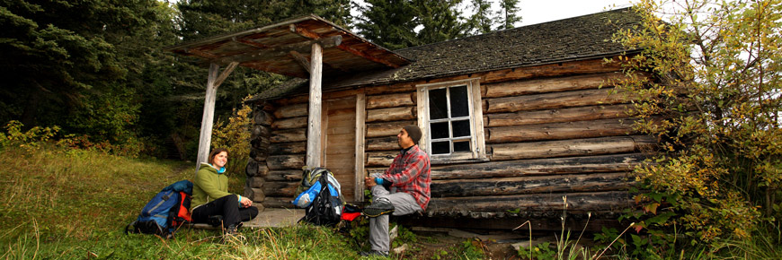 Un jeune couple est assis sur la galerie de la cabane de Grey Owl.