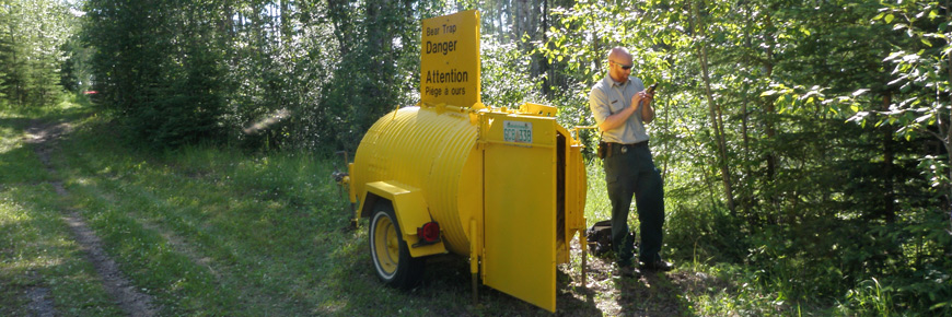 Un technicien en conservation des ressources de Parcs Canada indique l’emplacement d’un piège à ours au moyen d’un appareil GPS. 