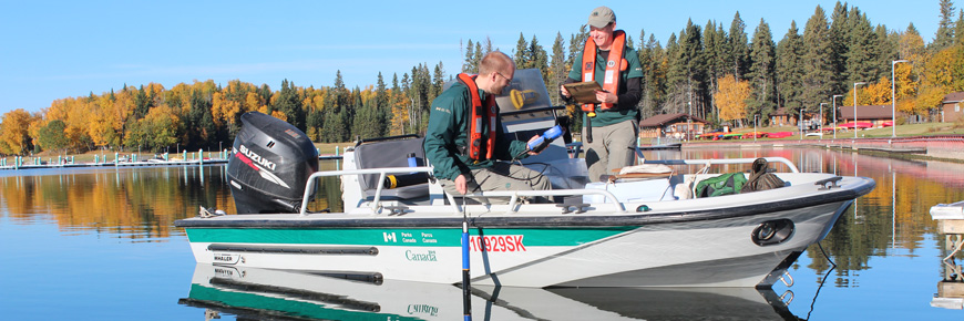Parks Canada staff members take water samples at the Waskesiu Lake marina. 