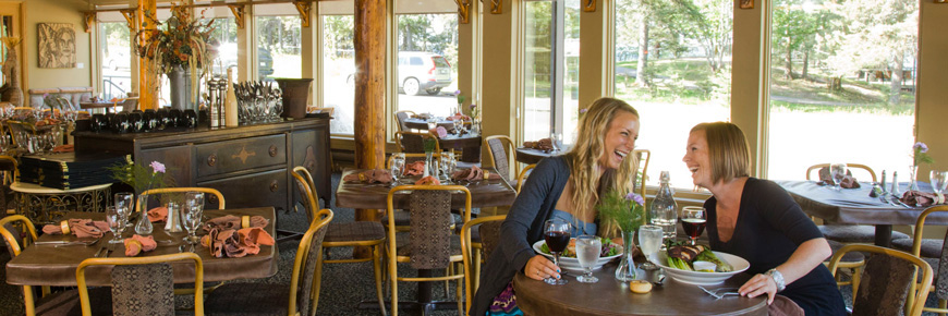 Two young ladies enjoy a meal at a table in an empty restaurant. 